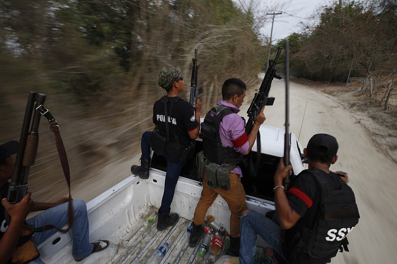 Members of a FUPCEG vigilante group patrol in Xaltianguis, Guerrero state, Mexico, Wednesday, May 29, 2019. The heavily armed vigilante force took over the town in the Mexican state of Guerrero last month by driving out a rival band, blowing up a car with gas cylinders and cutting up the body of one of two fallen foes. (AP Photo/Rebecca Blackwell)