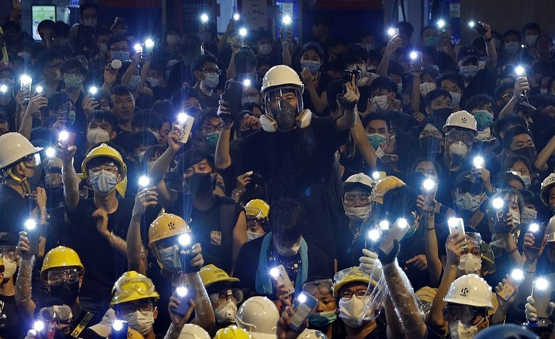 Protesters hold up the mobile phone lights in front of police headquarters in Hong Kong, Friday, June 21, 2019. More than 1,000 protesters blocked Hong Kong police headquarters into the evening Friday, while others took over major streets as the tumult over the city's future showed no signs of abating. (AP Photo/Vincent Yu)