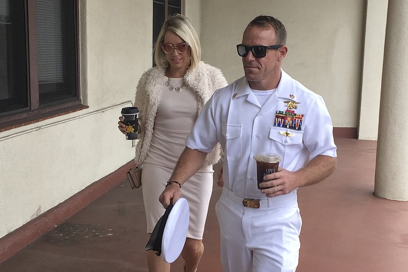 Navy Special Operations Chief Edward Gallagher, right, walks with his wife, Andrea Gallagher as they arrive to military court on Naval Base San Diego, Monday, June 24, 2019, in San Diego. Trial continues in the court-martial of the decorated Navy SEAL, who is accused of stabbing to death a wounded teenage Islamic State prisoner and wounding two civilians in Iraq in 2017. He has pleaded not guilty to murder and attempted murder, charges that carry a potential life sentence. (AP Photo/Julie Watson)