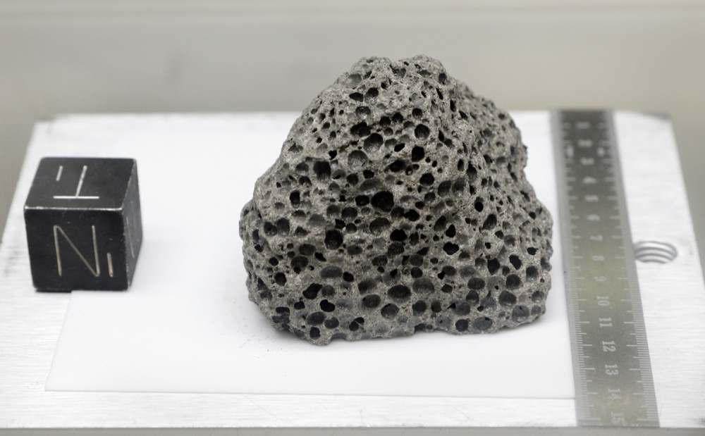 Collected during Apollo 15, a 3.5 billion years old basalt rock similar to rocks formed around Hawaii, is displayed in a pressurized nitrogen-filled examination case inside the lunar lab at the NASA Johnson Space Center Monday, June 17, 2019, in Houston. For the first time in decades, NASA is about to open some of the pristine samples and let geologists take a crack at them with 21st-century technology. (AP Photo/Michael Wyke)