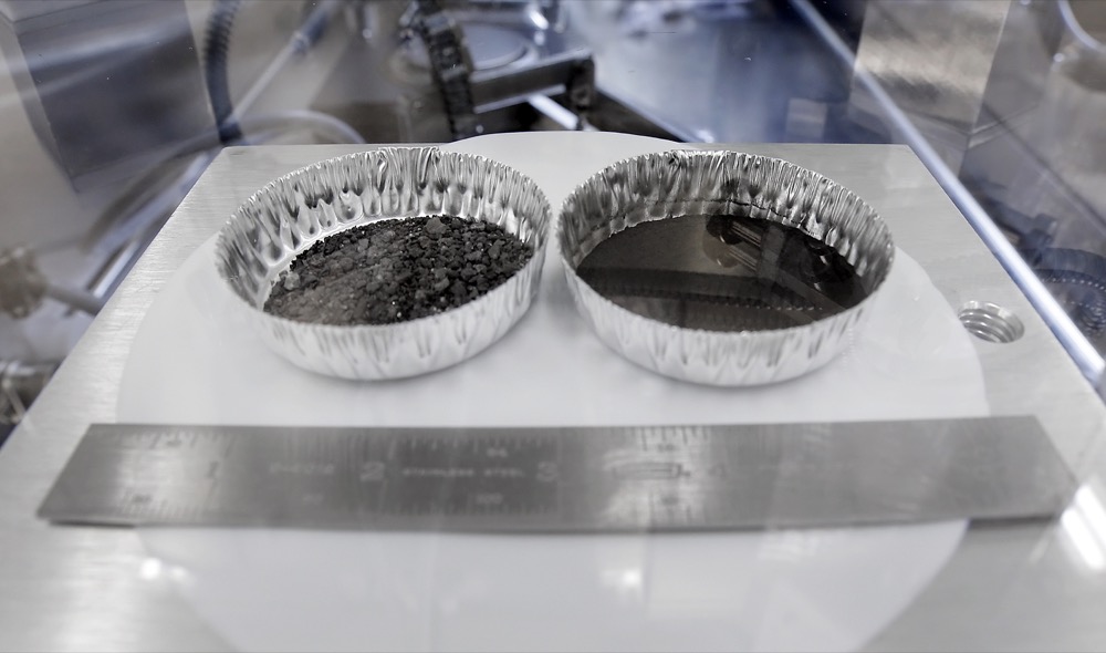 Two separate 2 inch foil pans hold lunar dirt, from the last shovel full collected by Neil Armstrong on the Apollo 11, in the lunar lab at the NASA Johnson Space Center Monday, June 17, 2019, in Houston. (AP Photo/Michael Wyke)