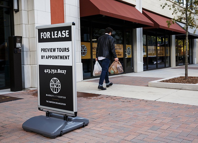 A passerby walks near the Market City Center apartment building in downtown Chattanooga. / Staff file photo by Doug Strickland