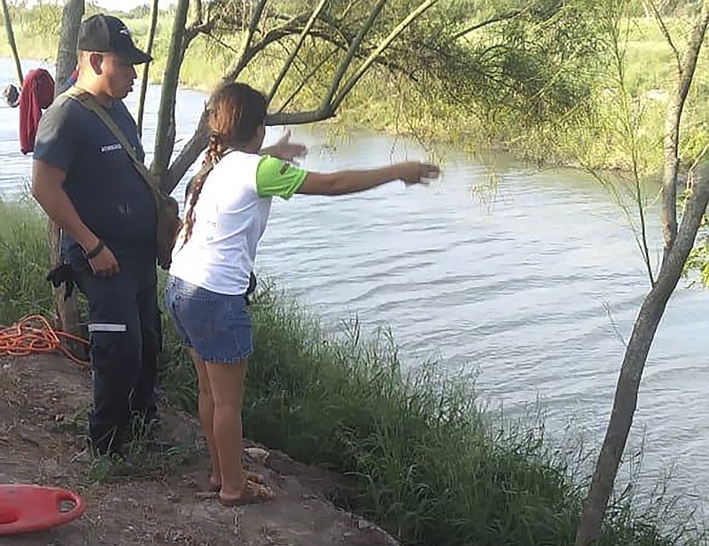 In this Sunday, June 23, 2019 photo, Tania Vanessa Ávalos of El Salvador speaks with Mexican authorities after her husband and nearly two-year-old daughter were swept away by the current while trying to cross the Rio Grande to Brownsville, Texas, in Matamoros, Mexico. Their bodies, the toddler still tucked into her father's shirt with her arm loosely draped around him, were discovered Monday morning several hundred yards (meters) from where they had tried to cross. (AP Photo/Julia Le Duc)