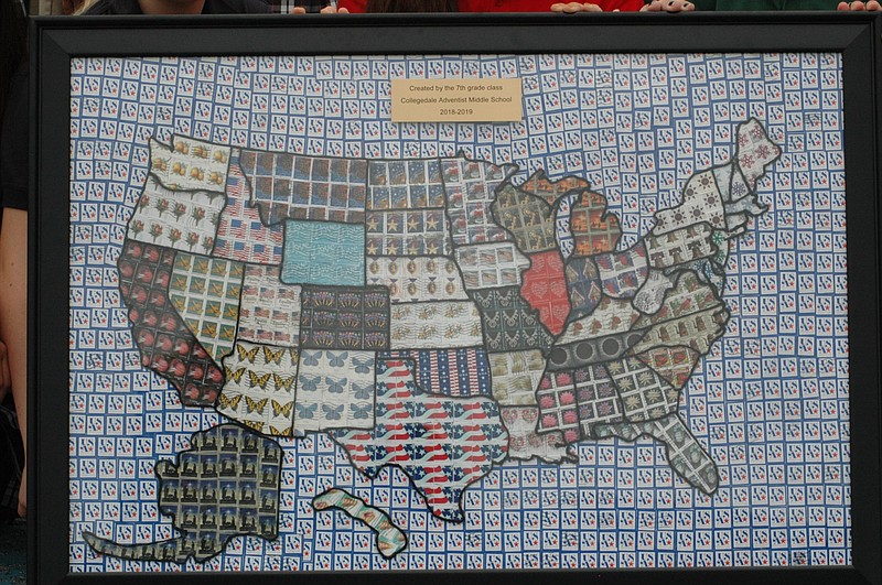 Hundreds of donated stamps were used to create a map of states that was donated by the seventh-grade class of Collegedale Academy to the Collegedale Post Office. "The hardest part is finding the same kind of stamp to do the whole ocean," says teacher Selena Trott. / Photo from Angi Howell