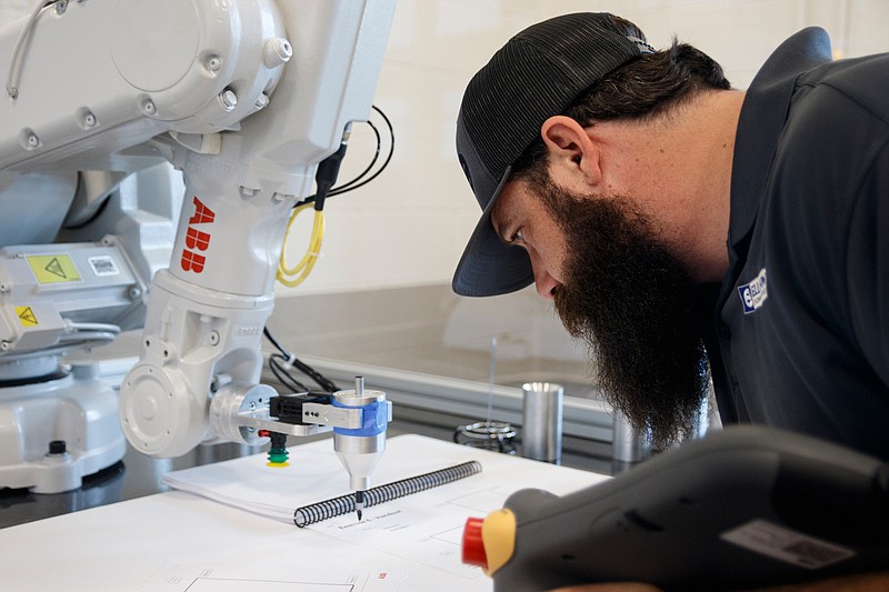 Josh Jones operates a robot in the ABS Training Lab during a class at Motlow State College's new Robotics Training Center on Wednesday, May 8, 2019, in McMinnville, Tenn. The school's mechatronics program will train students on robotics technology used at manufacturing plants like Volkswagen.