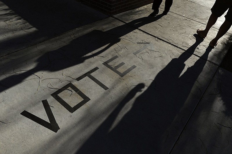  FILE - In this Nov. 6, 2018 file photo, voters head to the polls at the Enterprise Library, in Las Vegas. A new survey finds that more than 120 million Americans cast ballots in the 2018 midterm elections, with turnout surging in some states to that of a typical presidential year. The 2018 Election Administration and Voting Survey was released Thursday, June 27, 2019, by the U.S. Election Assistance Commission. (AP Photo/Joe Buglewicz, File)