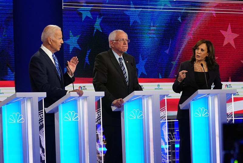 Sen. Kamala Harris, D-California and former Vice President Joe Biden gesture during an exchange about his opposition to federally imposed school busing for integration as Sen. Bernie Sanders, of Vermont, looks on during the Democratic presidential debate in Miami on Thursday. (Doug Mills/The New York Times)