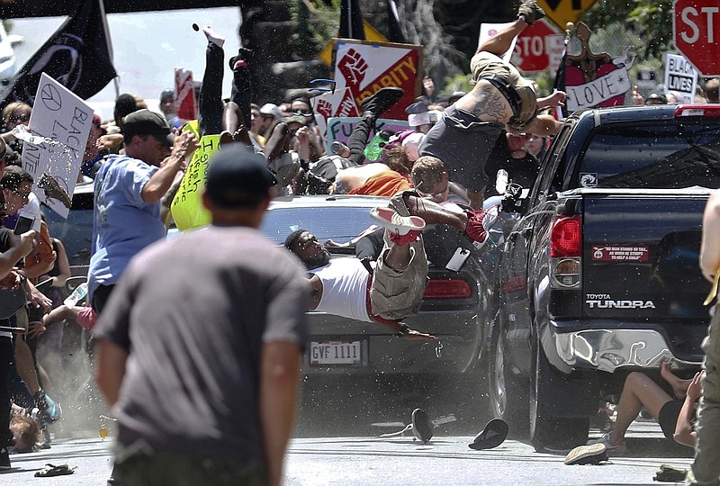 FILE - In this Aug. 12, 2017, file photo, people fly into the air as a vehicle is driven into a group of protesters demonstrating against a white nationalist rally in Charlottesville, Va. James Alex Fields Jr., the man accused of driving into the crowd demonstrating against a white nationalist protest, killing one person and injuring many more, has been sentenced to life in prison on hate crime charges, Friday, June 28, 2019.  (Ryan M. Kelly/The Daily Progress via AP, File)
