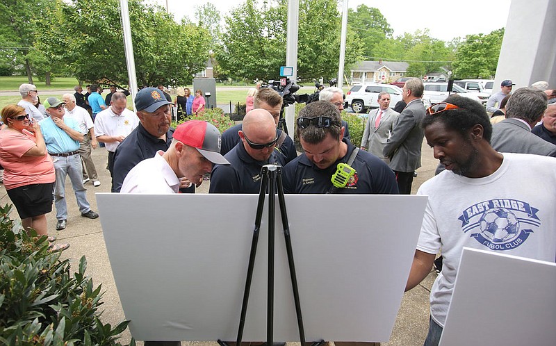 East Ridge firefighters and other community members check out the renderings for the new proposed Red Wolves professional soccer complex that was announced during a press conference in April at East Ridge City Hall.