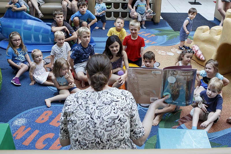 Kids listen as Shelley Headrick, a children's librarian at the Chattanooga Public Library's Northgate branch, reads "King Bidgood's in the Bathtub" at the play area in Northgate Mall on Monday, July 1, 2019 in Hixson, Tenn. The Chattanooga Public Library will hold "Story Time at the Play Area" the first Monday of each month. Yesterday's theme was "Royalty" and included a reading of "King Bidgood's in the Bathtub," the making of paper crowns and a visit from Aladdin and Jasmine.