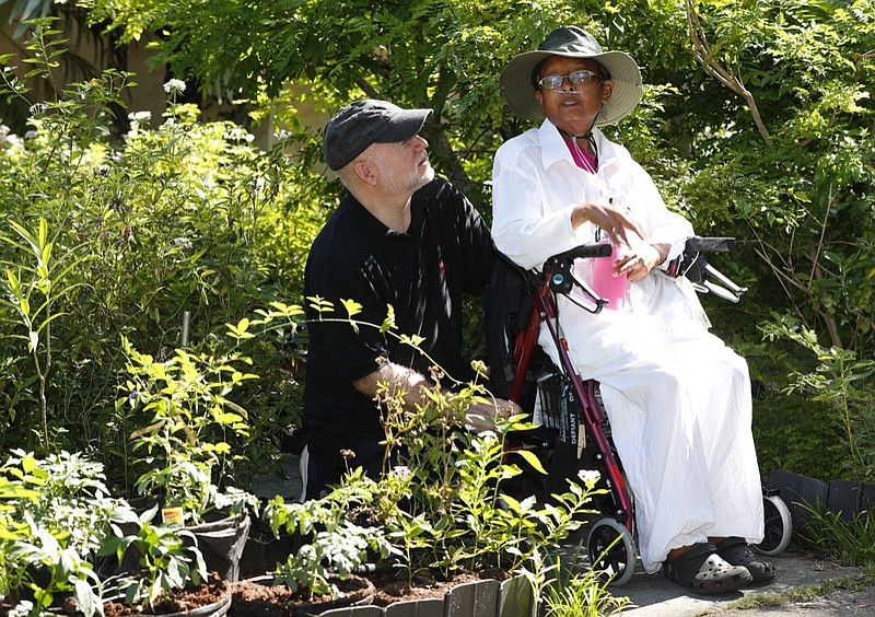 Homeowners Hermine Ricketts, right, and Tom Carroll chat as they speak to members of the media, Monday, July 1, 2019, in Miami Shores, Fla. The Miami-area couple held a ceremonial replanting of vegetables in their front yard as legislation to allow such gardens statewide went into effect July 1, following their long court battle to challenge a Village of Miami Shores' prohibition on front yard gardens. (AP Photo/Wilfredo Lee)
