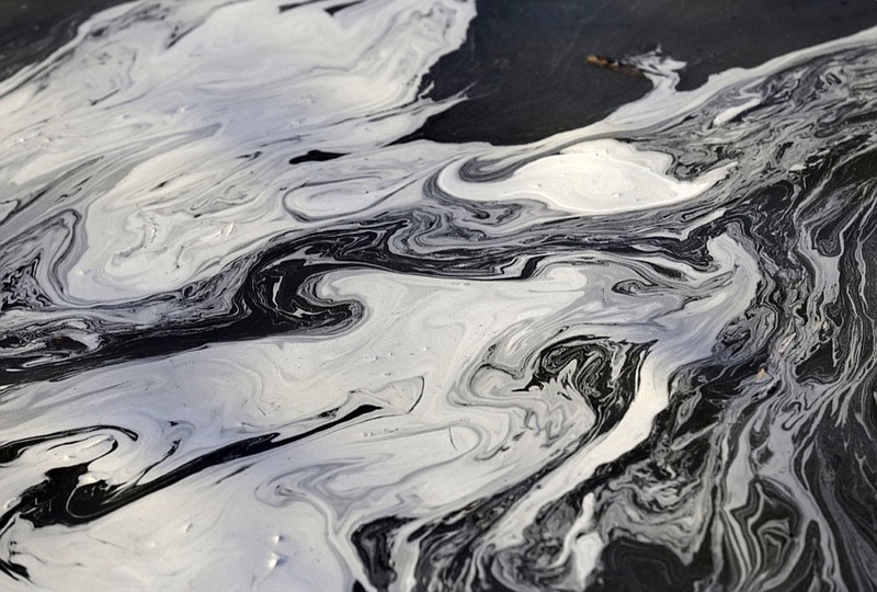 FILE - In this Feb. 5, 2014 file photo, coal ash swirls on the surface of the Dan River following one of the worst coal-ash spills in U.S. history into the river in Danville, Va. The Trump administration won t require electric utilities to show they have money to clean up hazardous releases from power plants despite a history of toxic coal ash spills contaminating waterways. EPA officials said Tuesday, July 2, 2019, that modern industry practices and recently-enacted regulations are sufficient to shield taxpayers from potential cleanup costs. (AP Photo/Gerry Broome, File)