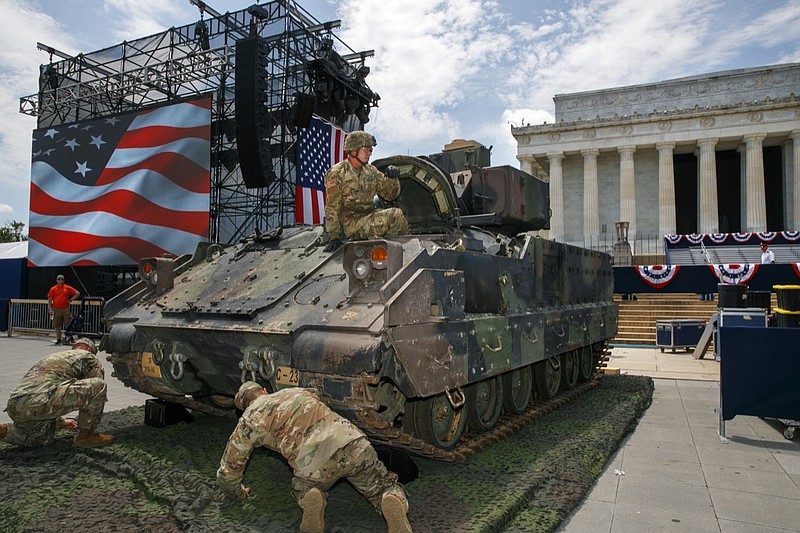 An Army soldier hops out of a Bradley Fighting Vehicle after moving it into place by the Lincoln Memorial, Wednesday, July 3, 2019, in Washington, ahead of planned Fourth of July festivities with President Donald Trump. (AP Photo/Jacquelyn Martin)