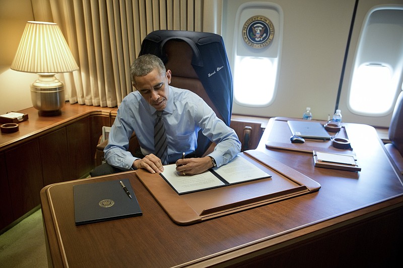 Then-President Barack Obama signs two immigration executive orders on board Air Force One in 2014, providing up to 4 million undocumented immigrants the ability to live in the U.S. without fear of immediate deportation. (Stephen Crowley/The New York Times)