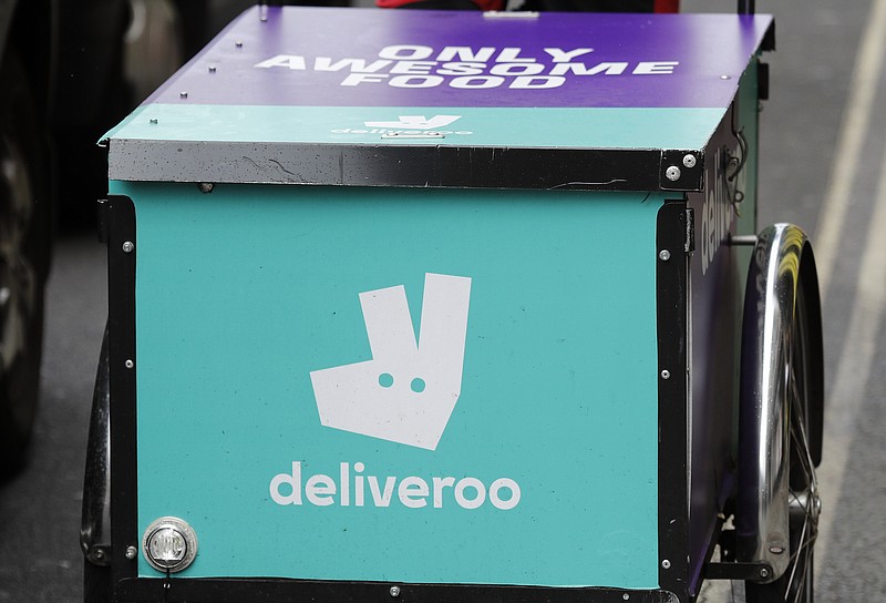 FILE - In this file photo dated Tuesday, July 11, 2017, a Deliveroo logo on a bicycle in London.  The U.K. competition watchdog has launched an investigation into Amazon’s purchase of a significant stake in food delivery service Deliveroo on Friday July 5, 2019, as the regulator is taking a more activist role in seeking to protect consumers in the evolving marketplace. (AP Photo/Frank Augstein, FILE)