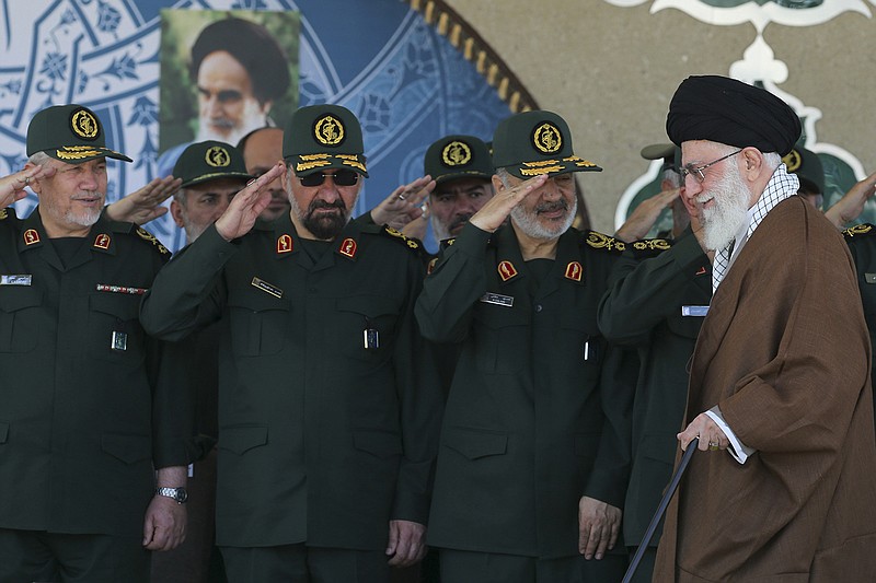 FILE- In this picture released by an official website of the office of the Iranian supreme leader, former commander of the Revolutionary Guard Mohsen Rezaei, second left, salutes Supreme Leader Ayatollah Ali Khamenei, right, while he arrives at a graduation ceremony of the Revolutionary Guard's officers, in Tehran, Iran.  Former leader of Iran's powerful Revolutionary Guard Mohsen Rezaei said on Friday, July 5, 2019, that the Islamic Republic should consider seizing a British oil tanker in response to authorities detaining an Iranian oil tanker off the coast Gibraltar. (Office of the Iranian Supreme Leader via AP, FILE)