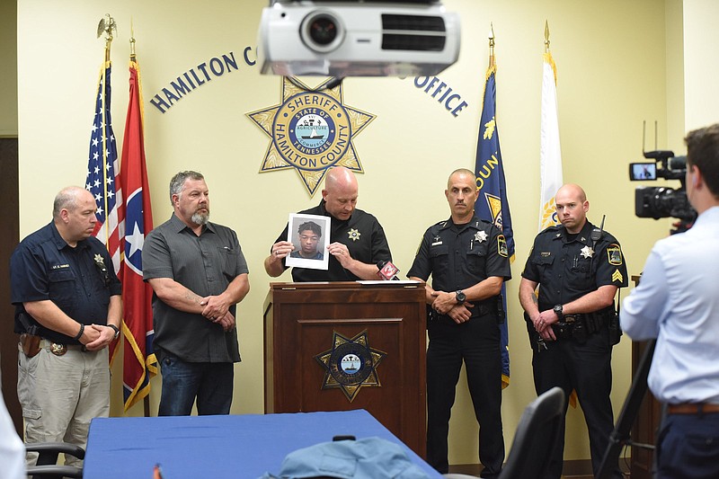 Hamilton County Sheriff's Office Chief Deputy Austin Garrett holds up a photo and asks the public for any information on the whereabouts of escaped convict Anthony Labron Bell, 29. Bell escaped while being treated in Erlanger hospital's Emergency Department early Sunday. Standing, from left are, Lt. Chris Harvey, Sgt. Mike Cox, Garrett, Deputy Chief Mark King and Sgt. Mickey Rountree.