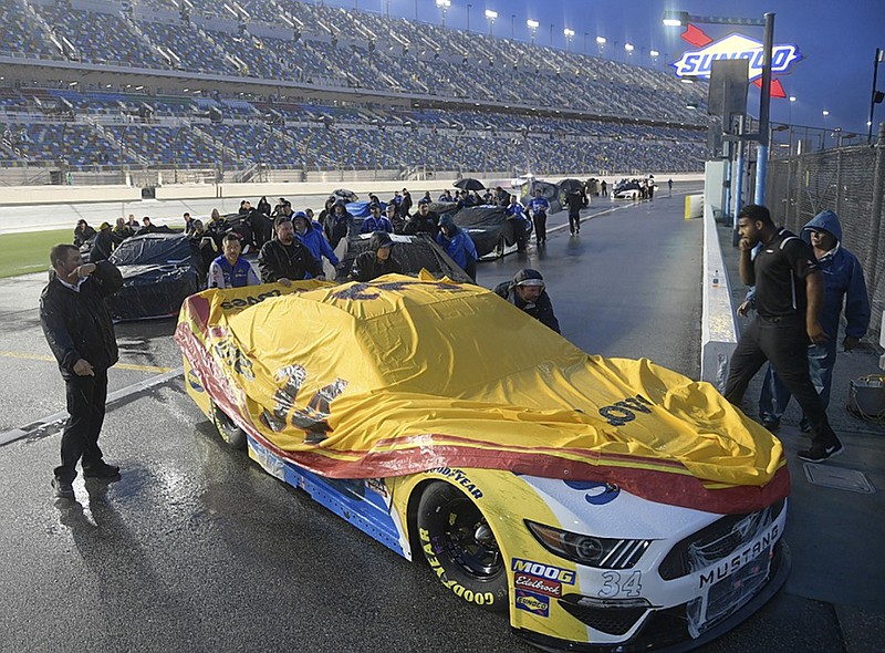 NASCAR driver Michael McDowell's crew pushes his car back to the garage after the Cup Series race was postponed because of inclement weather Saturday night at Daytona International Speedway in Daytona Beach, Fla. The race was rescheduled for 1 p.m. Sunday.