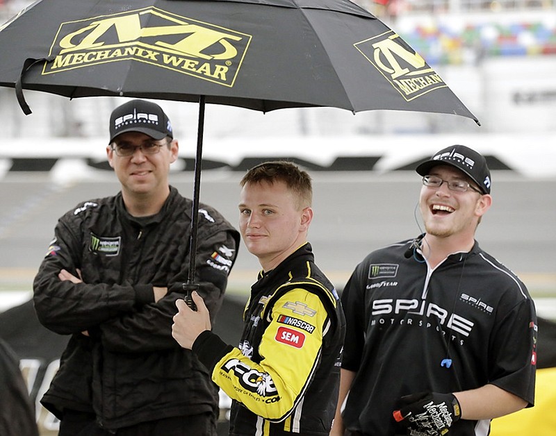 NASCAR driver Justin Haley, center, waits in the rain on pit road at Daytona International Speedway after the NASCAR Cup Series race was stopped because of inclement weather Sunday afternoon. Haley was declared the winner a short time later.
