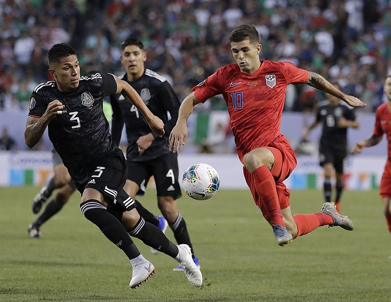 U.S. midfielder Christian Pulisic, right, controls the ball against Mexico defender Carlos Salcedo during the first half of the CONCACAF Gold Cup final Sunday at Soldier Field in Chicago. Mexico won 1-0.
