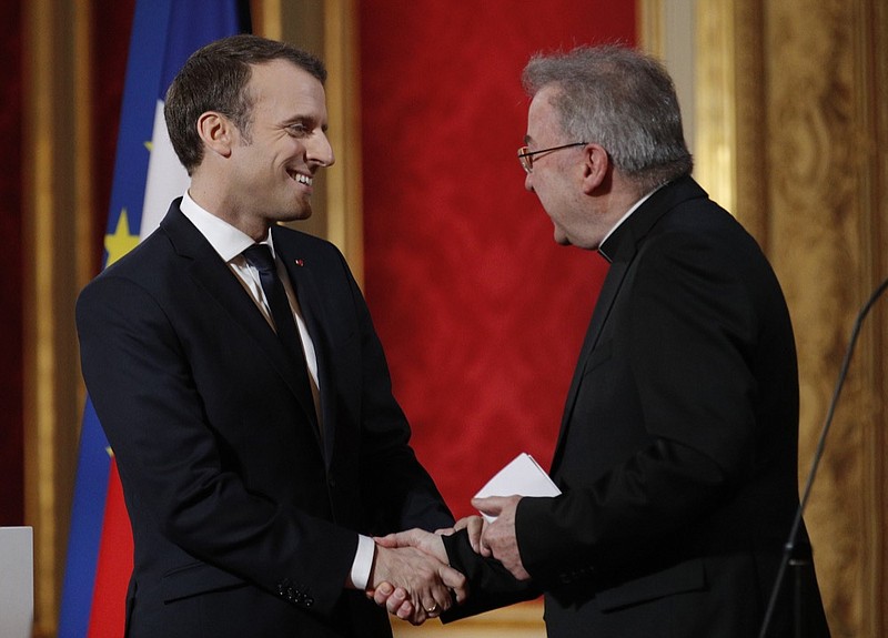 FILE - In this Jan.4, 2018 file photo, French President Emmanuel Macron, left, greets Apostolic Nuncio to France Luigi Ventura during his New Year address to diplomats at the Elysee Palace in Paris. France's foreign ministry says that the Vatican has decided to lift the immunity of its ambassador in France Archbishop Luigi Ventura, who is accused of sexual assault. (Yoan Valat, Pool via AP, File)