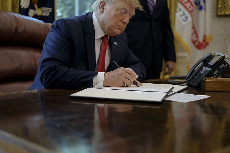 President Donald Trump signs an executive order imposing more sanctions on Iran inside the Oval Office at the White House in Washington on June 24. "We will continue to increase pressure on Tehran," Trump said. "Never can Iran have a nuclear weapon." (Gabriella Demczuk/The New York Times)