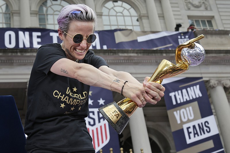 U.S. women's soccer player Megan Rapinoe celebrates with the FIFA Women's World Cup trophy at City Hall after a ticker tape parade, Wednesday, July 10, 2019 in New York. The U.S. national team beat the Netherlands 2-0 to capture a record fourth Women's World Cup title. (AP Photo/Seth Wenig)