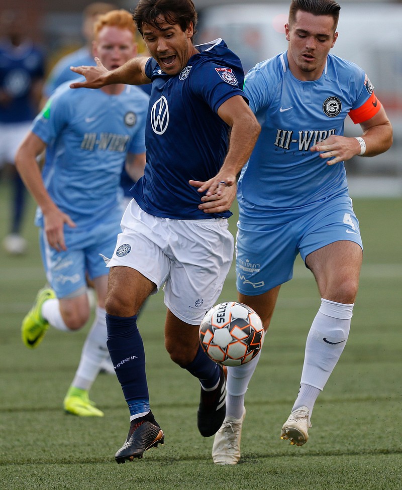 The Chattanooga Football Club's Jose "Zeca" Ferraz tries to get clear of Asheville City's Jamie Smith, right, in an NPSL Southeast match at Finley Stadium on June 29. Both teams will be back there Friday for conference semifinals at 4:30 and 7:30 p.m.