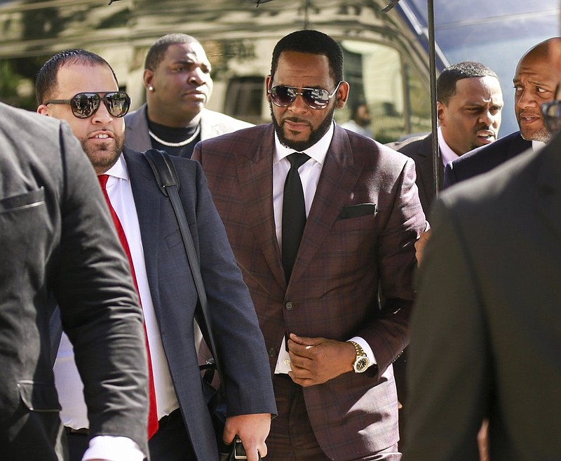 FILE - In this June 26, 2019, file photo, R&B singer R. Kelly, center, arrives at the Leighton Criminal Court building for an arraignment on sex-related felonies in Chicago. R. Kelly, already facing sexual abuse charges brought by Illinois prosecutors, was arrested in Chicago Thursday, July 11, 2019 on a federal grand jury indictment listing 13 counts including sex crimes and obstruction of justice. (AP Photo/Amr Alfiky, File)
