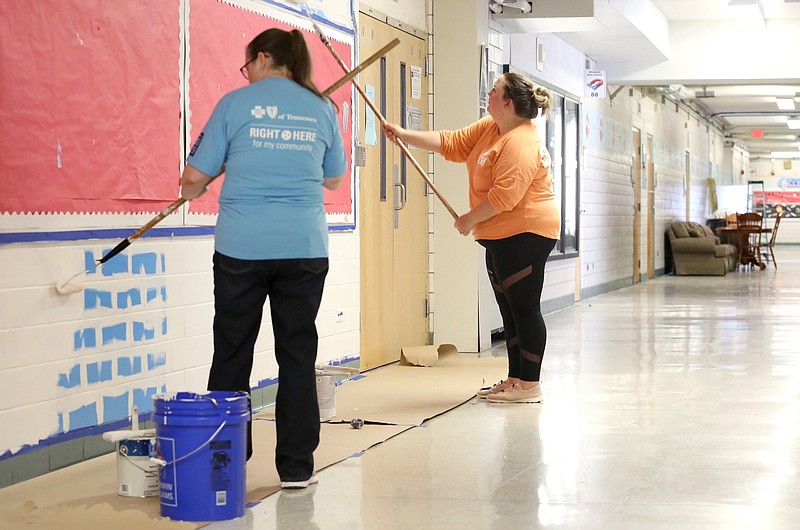Leah Ann Powell, a senior financial analyst at Blue Cross Blue Shield, and Hillacy Williams, a billing coordinator at Unum, paint over blue walls at Brainerd High School Friday, June 21, 2019 in Chattanooga, Tennessee. Classrooms were painted earlier in the week.