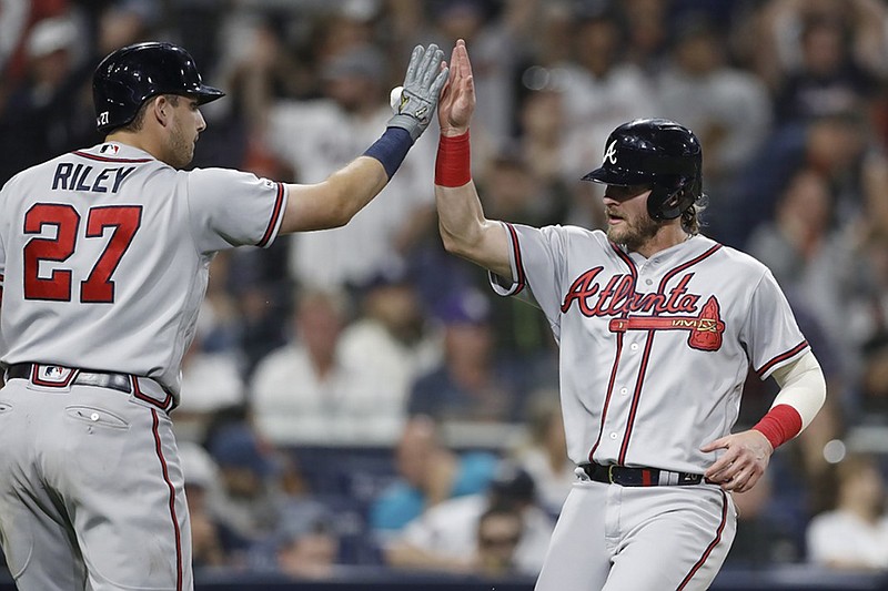 Josh Donaldson, right, is greeted by rookie teammate Austin Riley after scoring on a single by Ozzie Albies during the 10th inning of the Atlanta Braves' victory against the host San Diego Padres on Saturday night.