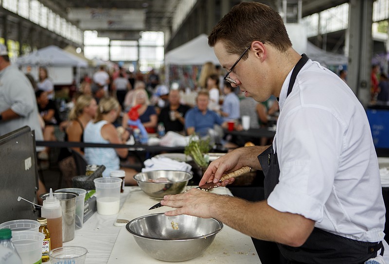 SideTrack's Jason Greer competes during the FiveStar Food Fight at the Chattanooga Market at the First Tennessee Pavilion on Sunday, July 14, 2019 in Chattanooga, Tenn. Greer won the competition with a fried chicken dish. Five local chefs competed in the competition for a chance to win a Golden Ticket into the 2019 World Food Championships. Each chef had an identical cooking station and were given chicken from Springer Mountain Farms. The chefs used the chicken, one "lottery" ingredient and ingredients purchased on-site at the Market with a provided $50 to create their dishes.