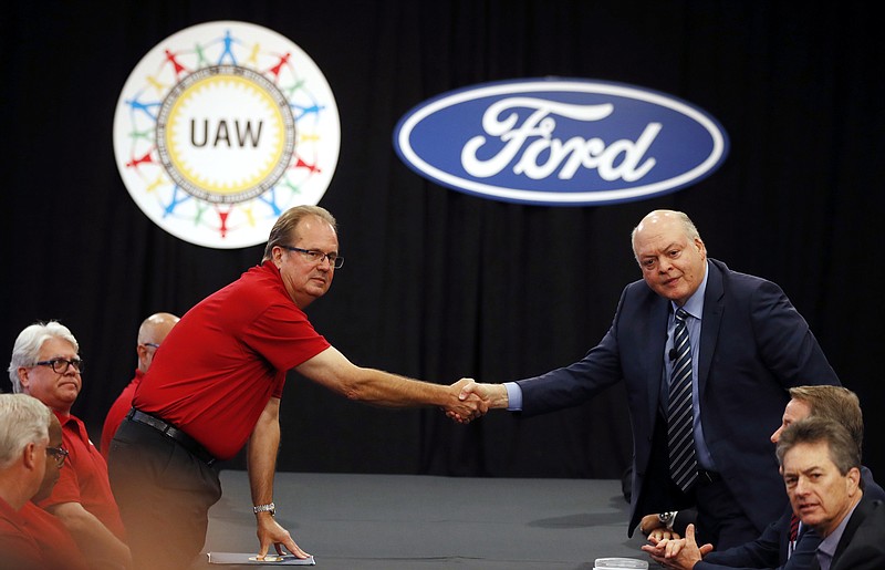 United Auto Workers President Gary Jones, left, and Ford Motor Co., Chief Executive Officer Jim Hackett shake hands to open their contract talks Monday, July 15, 2019, in Dearborn, Mich. (AP Photo/Carlos Osorio)