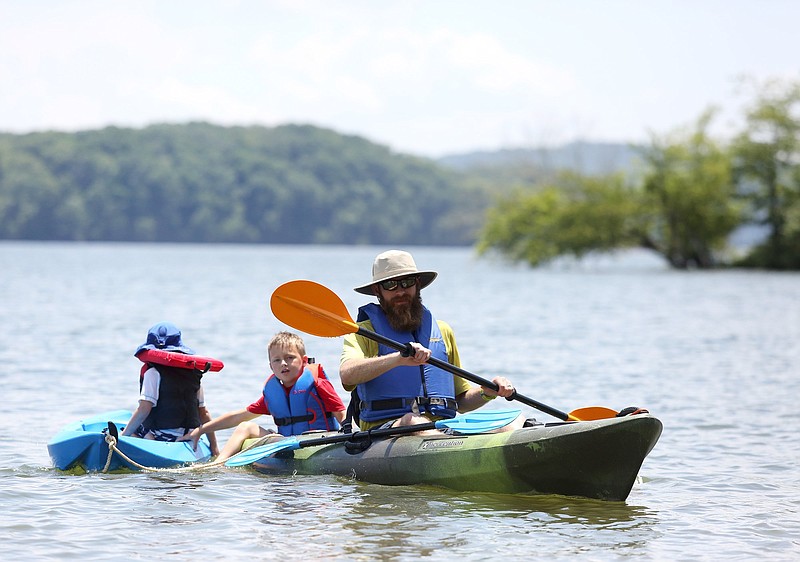 Jonathan Prater pulls his two sons, Branch Prater, 3, and Knox Prater, 5, as he kayaks toward the shore Friday, July 5, 2019 at Chester Frost Park in Hixson, Tennessee. Temperatures were in the low to mid 90s Friday, and many people were taking advantage of the cool water.