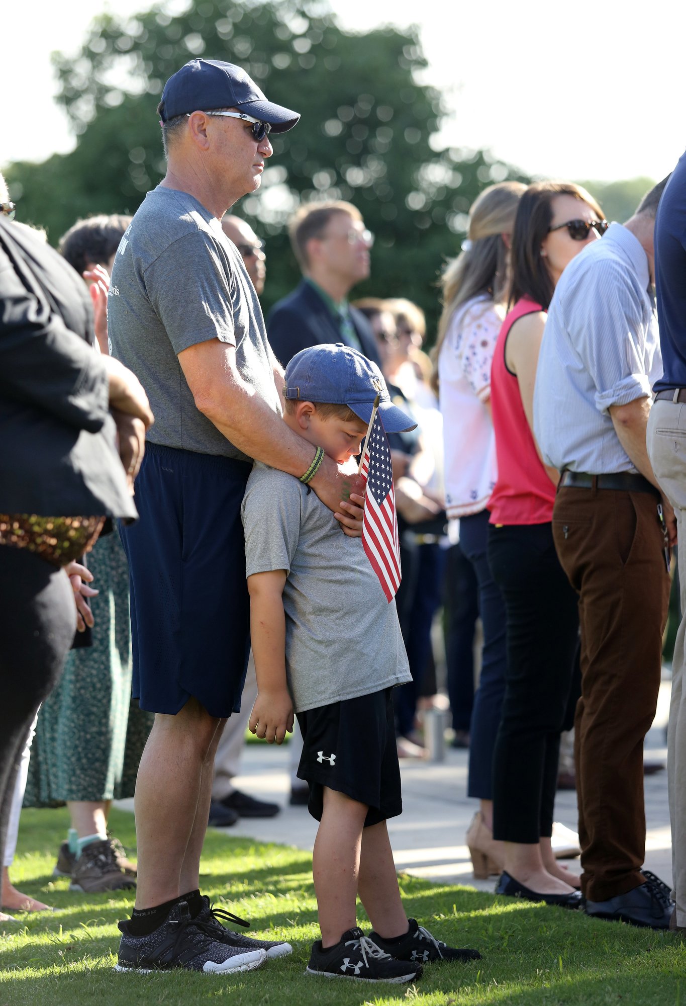 Craig Johnson and his grandson, Jackson Thompson, 7, stand together holding a flag during a ceremony to remember the Fallen Five at Chamberlain Field Pavilion at the University of Tennessee at Chattanooga. Today marked four years since the attack by a lone gunman at a Lee Highway military recruiting center and the Naval Operational Support Center and Marine Corps Reserve Center off of Amnicola Highway.