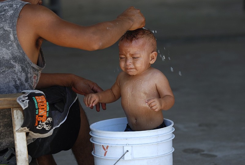 A migrant baby is given a bath at the AMAR migrant shelter in Nuevo Laredo, Mexico, Tuesday, July 16, 2019. A U.S. policy to make asylum seekers wait in Mexico while their cases wind through clogged U.S. immigration courts has also expanded to the violent city of Nuevo Laredo. (AP Photo/Marco Ugarte)