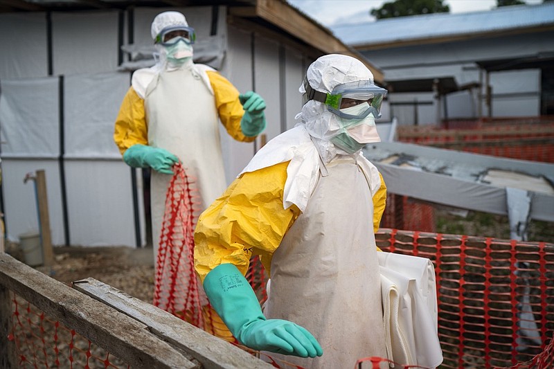 In this photograph taken Saturday July 13, 2019, health workers wearing protective suits take their shift at a treatment center in Beni, Congo DRC. The head of the World Health Organization is convening a meeting of experts Wednesday July 17, 2019 to decide whether the Ebola outbreak should be declared an international emergency after spreading to eastern Congo's biggest city, Goma, this week. More than 1,600 people in eastern Congo have died as the virus has spread in areas too dangerous for health teams to access.(AP Photo/Jerome Delay)