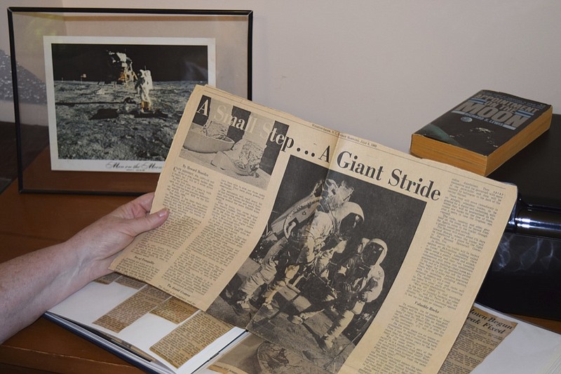 This 2019 photo provided by Cathy Goff shows her with newspaper clippings about the Apollo 11 moon landing mission at her home in King, N.C. In July 1969, the then 14-year-old Cathy, an avid Star Trek and science fiction fan, was spending the week cutting newspaper clippings of the Apollo 11 mission for a school science project: "I remember my mother letting my sister and me stay up late to watch the moon walk. I love anything space related. ... I got to meet Buzz Aldrin at the Star Trek 30th anniversary convention in Huntsville, Alabama. It was one of the greatest thrills of my life!" (Courtesy Cathy Goff via AP)