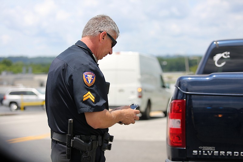 Chattanooga police traffic investigator Joe Warren examines information from a driver he pulled over in June.