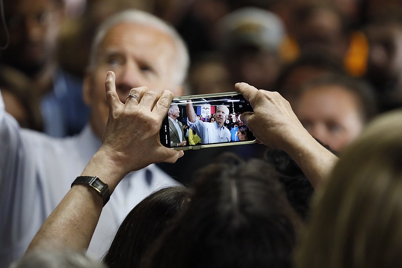 An audience member takes a photo of Democratic presidential candidate former Vice President Joe Biden during a community event, Wednesday, July 17, 2019, in Council Bluffs, Iowa. (AP Photo/Charlie Neibergall)