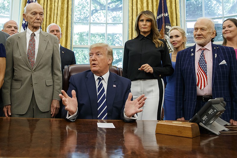 President Donald Trump, accompanied by Apollo 11 astronauts Michael Collins, left, and Buzz Aldrin, right, with Vice President Mike Pence and first lady Melania Trump, speaks during a photo opportunity commemorating the 50th anniversary of the Apollo 11 moon landing, in the Oval Office of the White House, Friday, July 19, 2019, in Washington. (AP Photo/Alex Brandon)