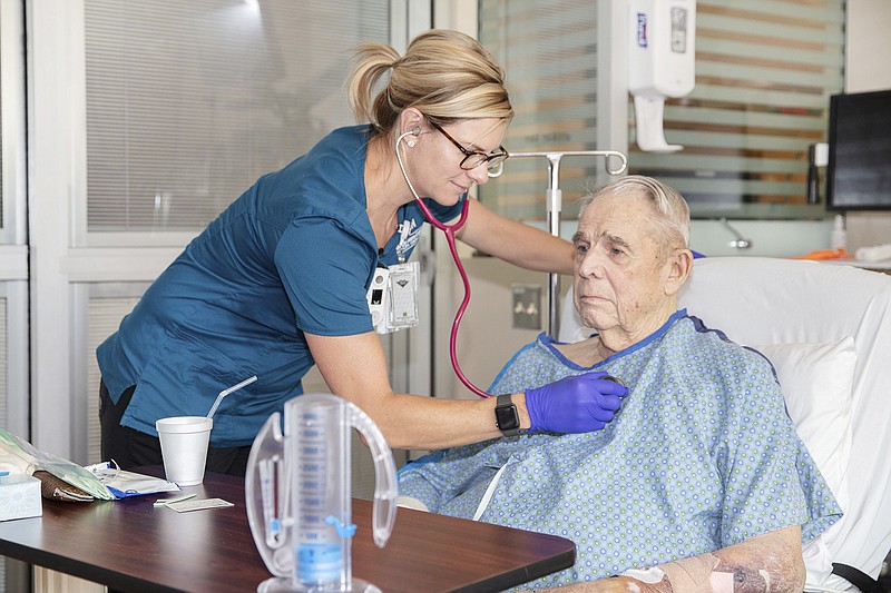 In this July 16, 2019 photo provided by the VA Eastern Colorado Health Care System, George Barrett, 85, of Lakewood, Colo., is checked by nurse Renee Whitley as he recuperates from open-heart surgery at the Rocky Mountain Regional VA Medical Center in Aurora, Colo. The hospital helped the American College of Surgeons test new standards to improve surgical care for older adults. (Shawn Fury/VA Eastern Colorado Health Care System via AP)