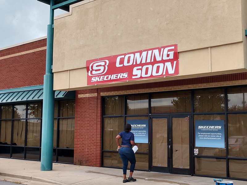 Staff photo by Mike Pare / A woman walks into a planned Skechers store at Hamilton Crossing that's slated to open early next month.