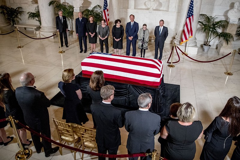 From center left, retired Associate Justice Anthony Kennedy, Ashley Kavanaugh, the wife of Associate Justice Brett Kavanaugh, Associate Justice Elena Kagan, Associate Justice Sonia Sotomayor, Associate Justice Samuel Alito, Associate Justice Ruth Bader Ginsburg, and Chief Justice John Roberts participates in a ceremony along with family, below, for the late Supreme Court Justice John Paul Stevens as he lies in repose in the Great Hall of the Supreme Court in Washington, Monday, July 22, 2019. (AP Photo/Andrew Harnik, pool)