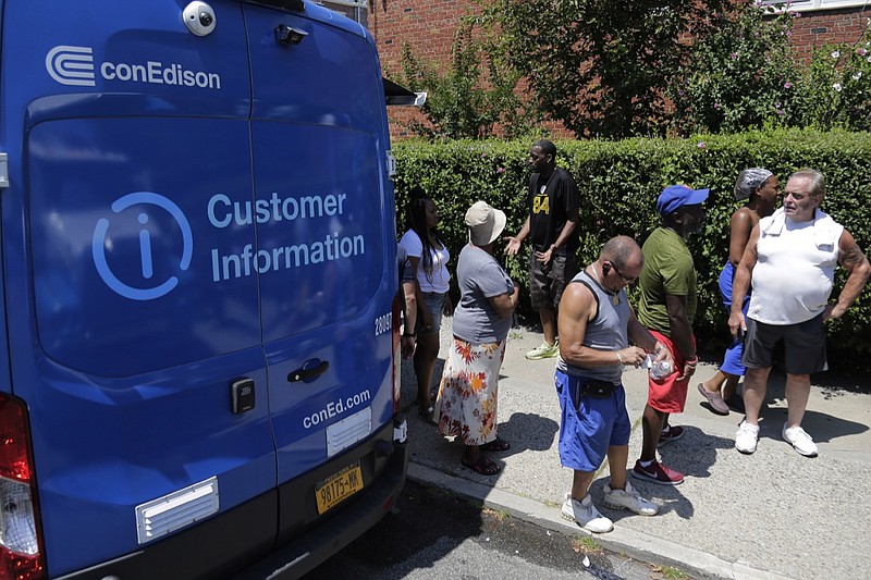 People line up to get dry ice from a Con Edison truck in a neighborhood without power in the Brooklyn borough of New York, Monday, July 22, 2019. Mayor Bill de Blasio called for an investigation Monday of power outages that came at the end of this weekend's oppressive heat, saying he no longer trusts utility Con Edison after it decided to turn off power to thousands of customers. (AP Photo/Seth Wenig)