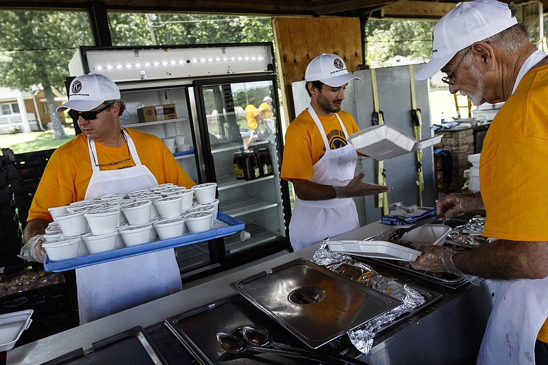 Bill Payne, left, George Gulas, center, and Stacy Landrum prepare plates at the East Brainerd Kiwanis Club's 71st annual barbecue at the Tennessee Baptist Children's Home on Lee Highway on Saturday, July 29, 2017, in Chattanooga, Tenn.