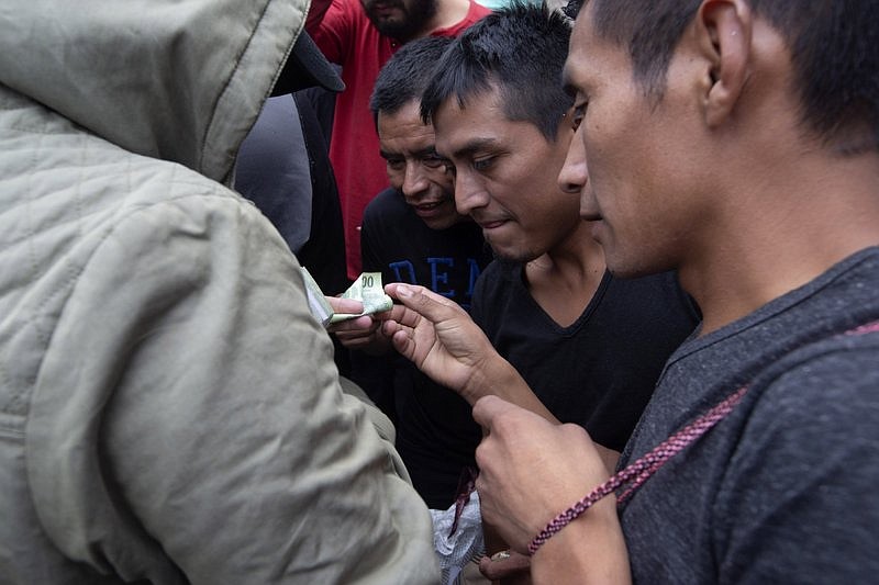 Guatemalan men who were deported from the United States, change money after arriving at the Air Force Base in Guatemala City, Tuesday, July 16, 2019. Nearly 200 Guatemalan migrants have been deported on Tuesday, the day the Trump administration planned to launch a drastic policy change designed to end asylum protections for most migrants who travel through another country to reach the United States. (AP Photo/Moises Castillo)

