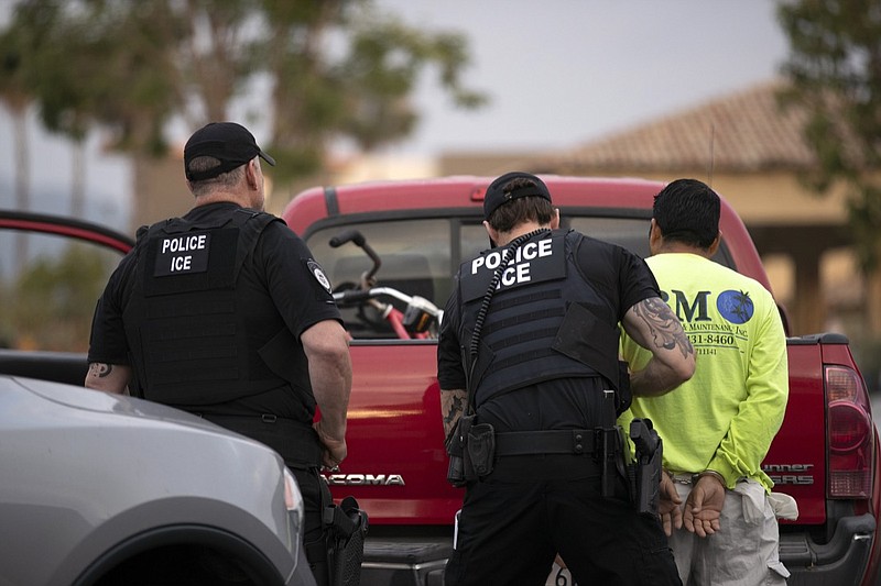 In this July 8, 2019 file photo, U.S. Immigration and Customs Enforcement (ICE) officers detain a man during an operation in Escondido, Calif. The administration of President Donald Trump announced Monday, July 22, 2019 that it will vastly expand the authority of immigration officers to deport migrants without allowing them to first appear before judges, its second major policy shift on immigration in eight days. Starting Tuesday, fast-track deportations can apply to anyone in the country illegally for less than two years. (AP Photo/Gregory Bull, File)