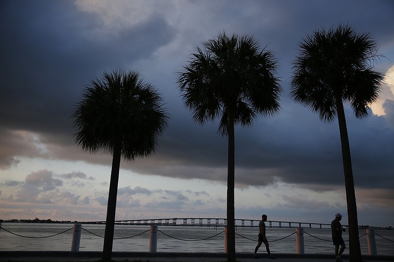 In this June 4, 2019, photo two people walk along the water in the early morning sunrise near downtown Miami in Key Biscayne, Fla. Some debts that bring the promise of opportunity, like student loans or mortgages, might seem “good,” but that's not always the case. And having credit card debt isn't always bad. What makes debt “good” or “bad” depends on how it fits into your overall financial picture. (AP Photo/Brynn Anderson)