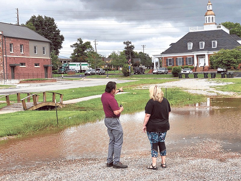 McCracken Poston and Denni Thomas look at a pool of water that formed in Ringgold when heavy rain swept through the town July 9. (Photo by Davis Lundy)